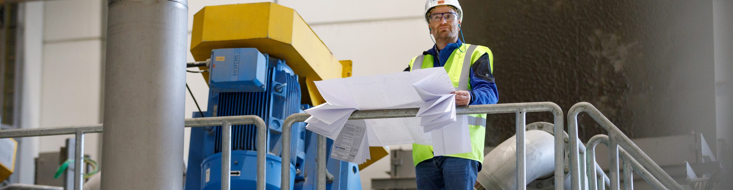 Zwei Ingenieure prüfen Konstruktionspläne vor Ort beim Kunden